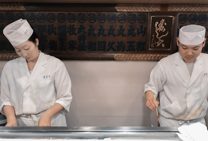 two sushi chefs preparing sushi